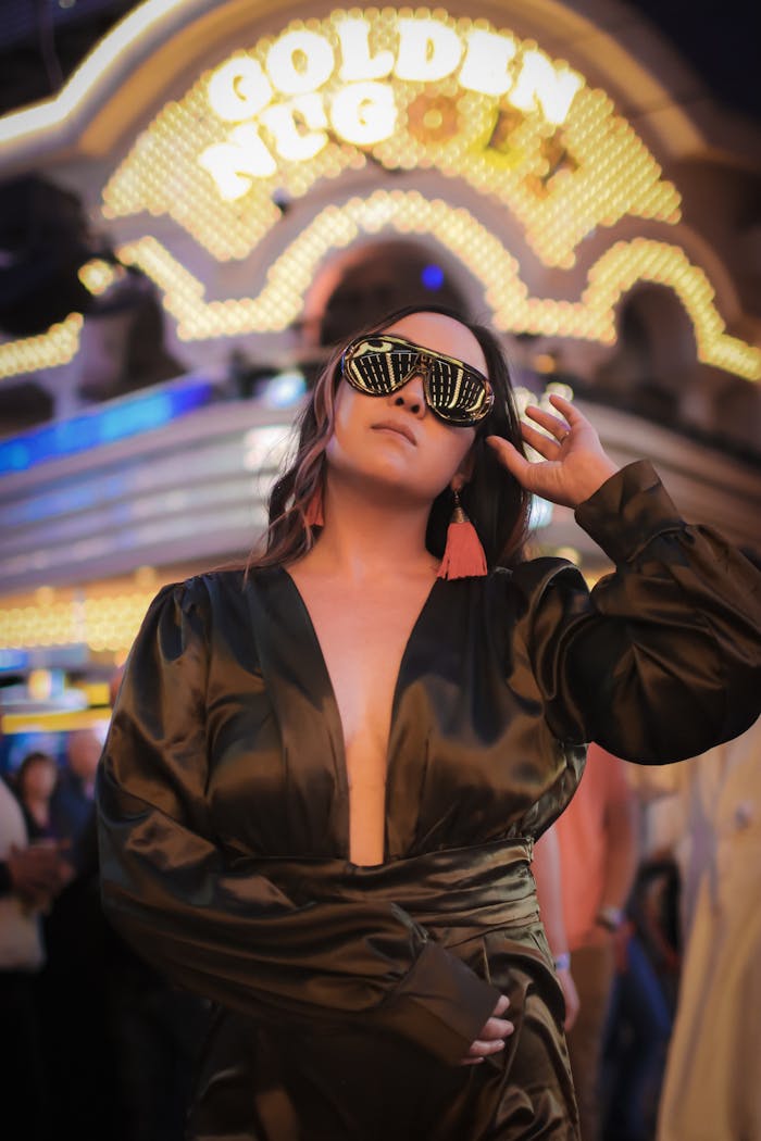 Woman in fashionable black outfit with neon lights background at night
