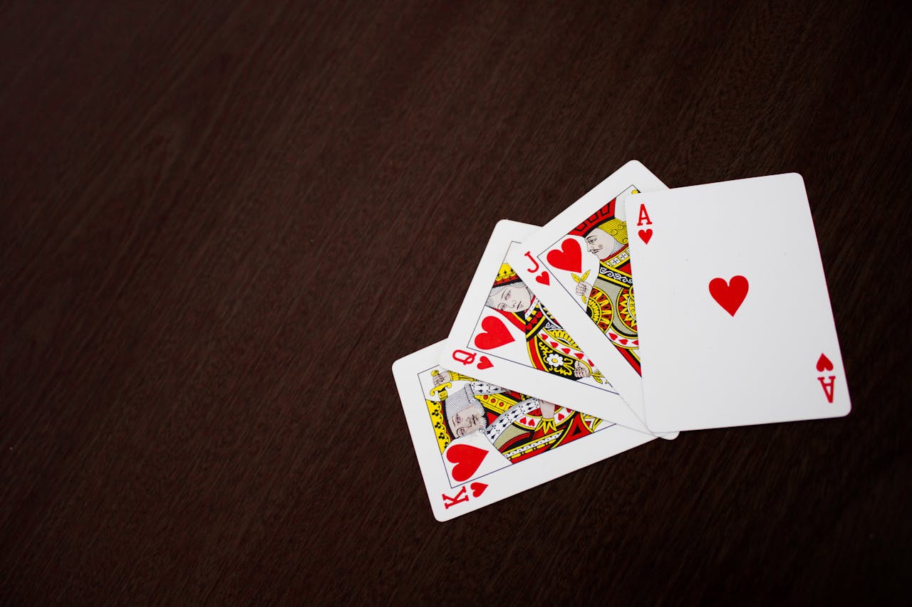 services-03 Elegant flat lay of playing cards featuring ace of hearts on a wooden surface.